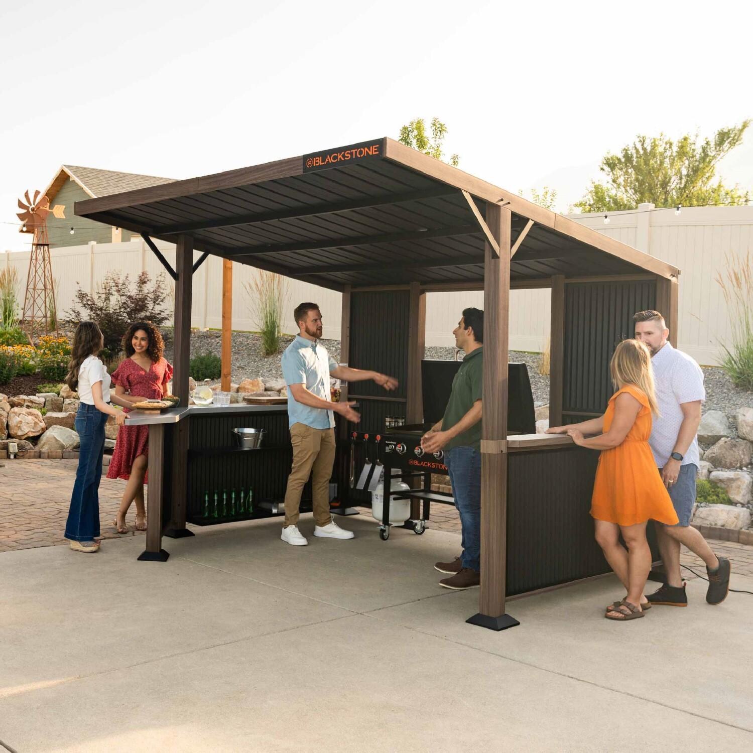 Blackstone 10 x 10-Foot Bar and Griddle/Grill Pavilion - Entertaining Friends at Grill - Lifestyle thumbnail