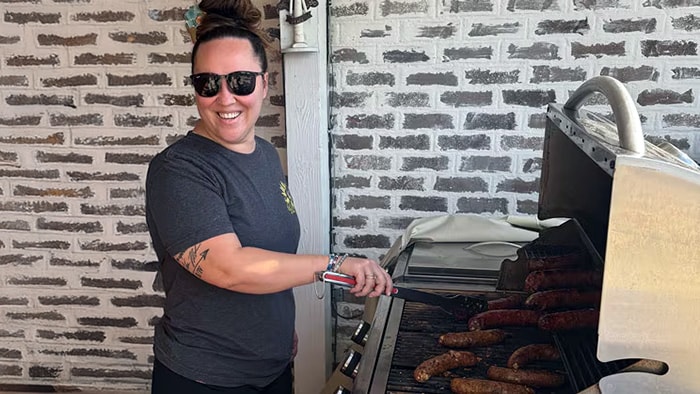 Brandi grilling sausages in her backyard