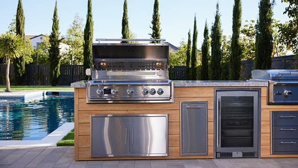 Blaze LTE Pro gas grill built into a luxury outdoor kitchen island next to a pool