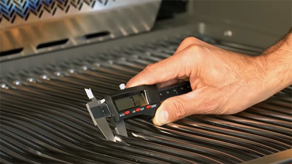 Chef Tony measures the cooking grid thickness with digital calipers.