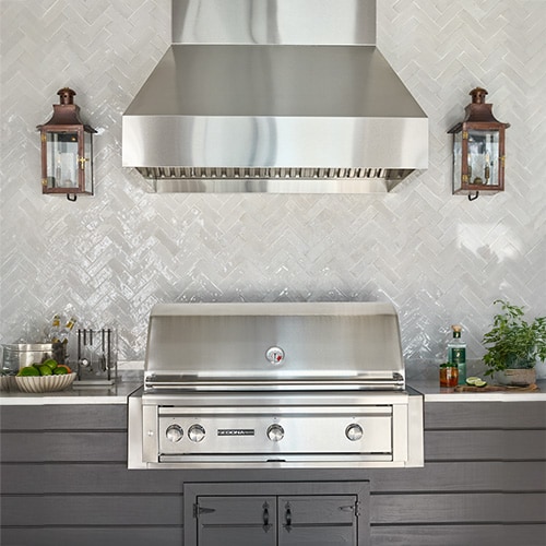 Wall mounted vent hood installed over a grill
