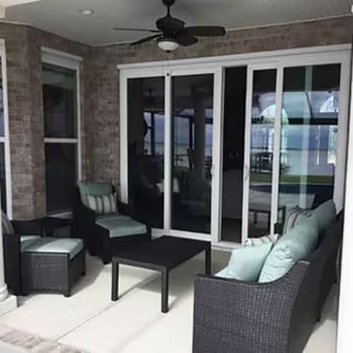 Brick outdoor living space with stylish black furniture with gray cushions