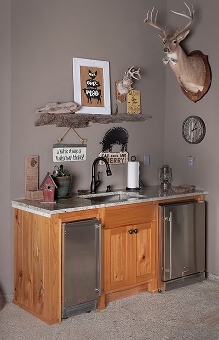 Two refrigerators built into cabinets with a sink installed as well
