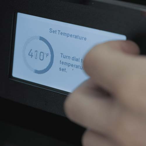 Adjusting the temperature on a pellet grill.