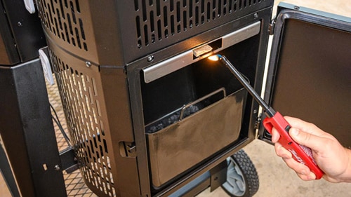 Lighting the charcoal hopper with a bbq lighter