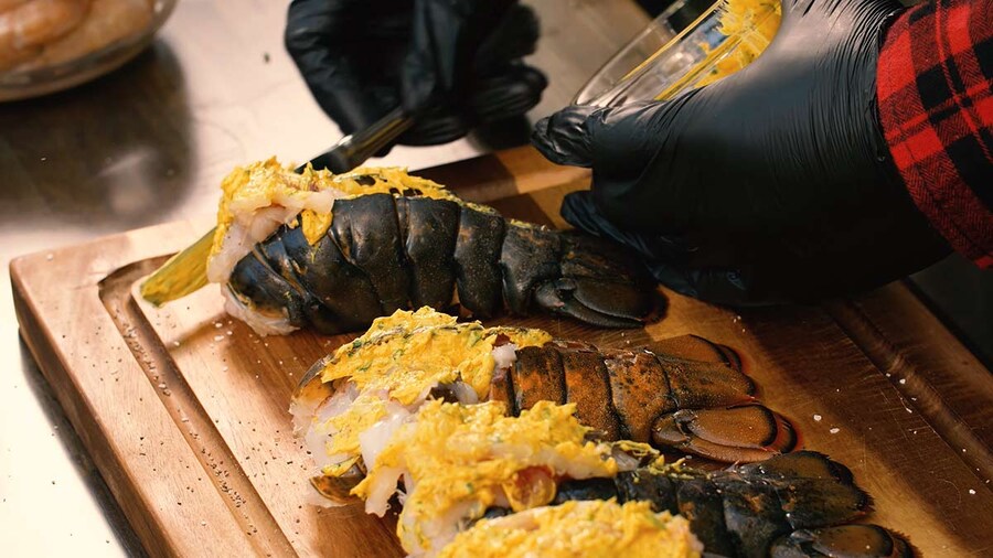 Rasheed applying butter to lobster
