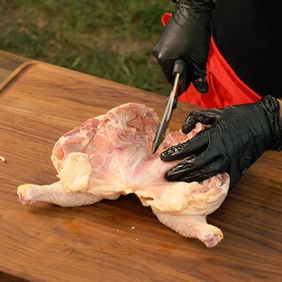 Kelsey Heidkamp cutting the breastbone of the chicken
