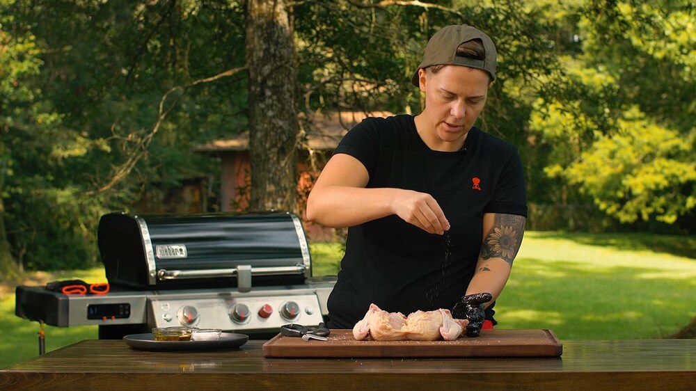 Kelsey Heidkamp seasoning a spatchcocked chicken