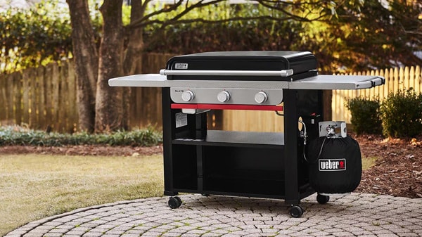 Freestanding Weber Slate gas griddle on a backyard patio