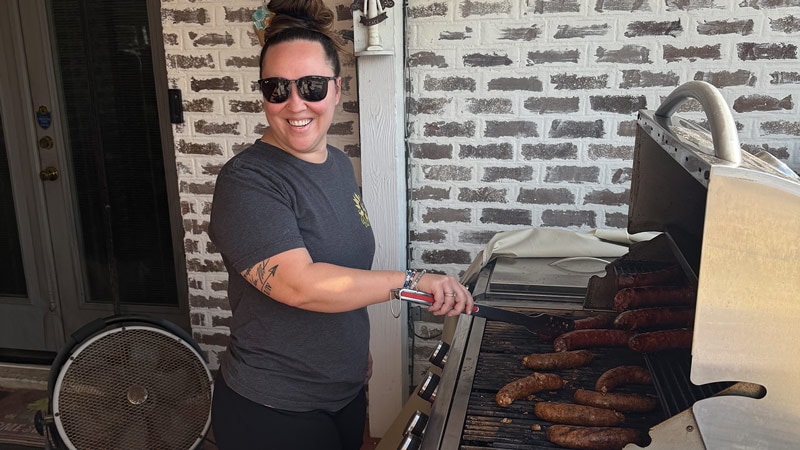 Brandi grilling sausages in her backyard