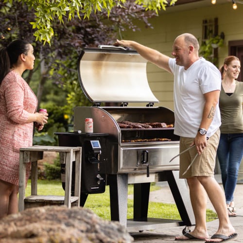 Griller checks on bbq ribs in their smoker