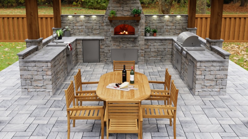 Stone-clad outdoor kitchen, with a dining table, chairs, grill, pizza oven, and refrigerator