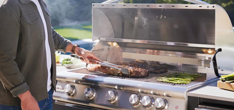 Blaze gas grill with food cooking, lid open