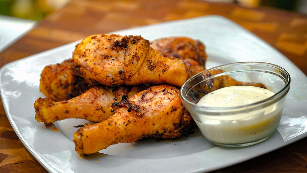 Grilled chicken wings on a plate with ranch dipping sauce