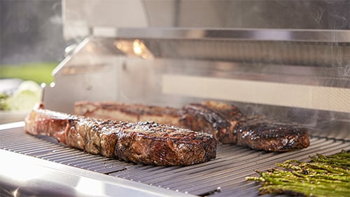 steaks and asparagus on a gas grill