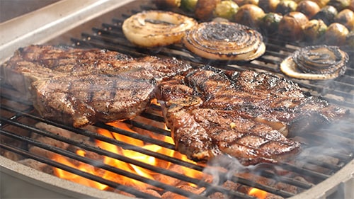 steaks grilling on a gas grill