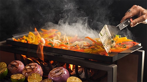 onions peppers and limes being grilled over live fire