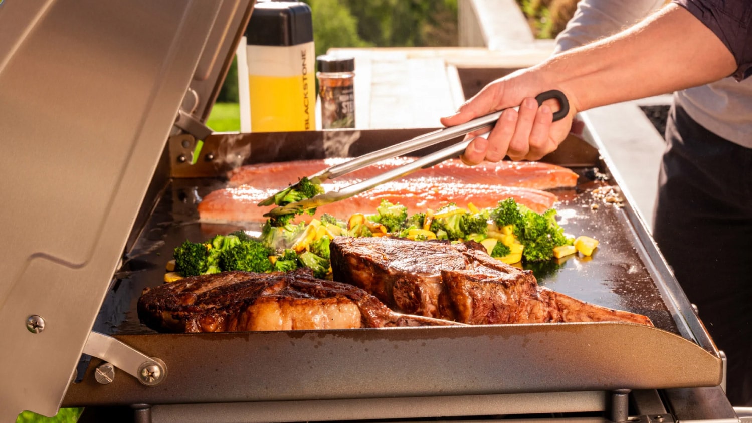 Grilling steak, fish, and vegetables on a gas griddle