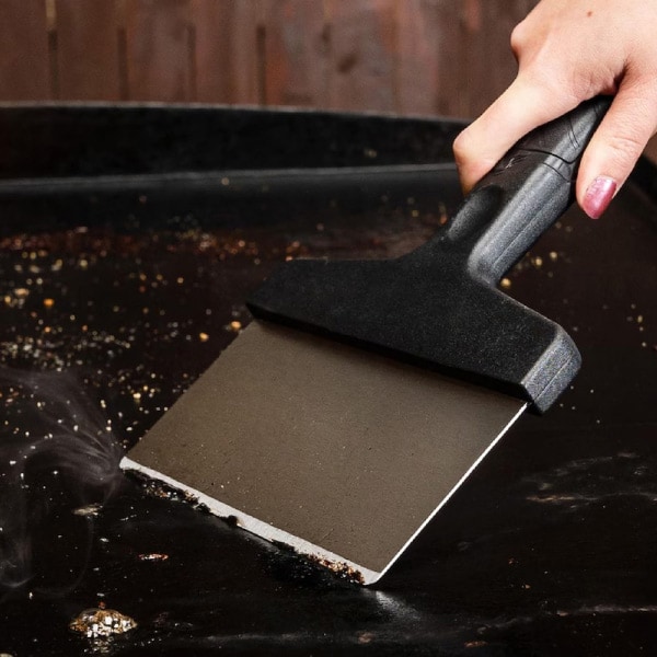Scraping debris from griddle surface