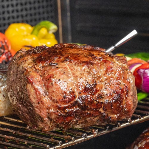 MEATER bluetooth meat thermometer sticking out of a pork roast
