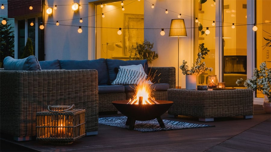 outdoor patio at night with string lights and fire pit