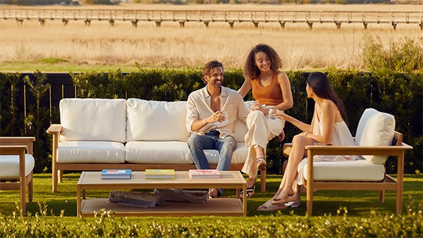 people sitting on a teak patio furniture set outside