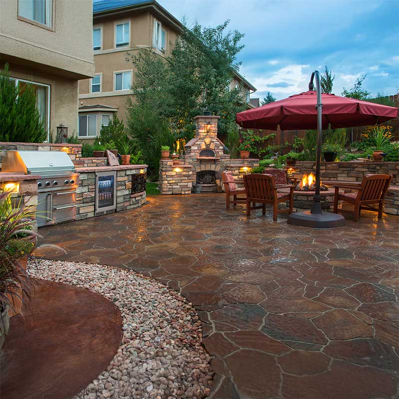 4 season outdoor kitchen with lights, umbrella, and fire pit