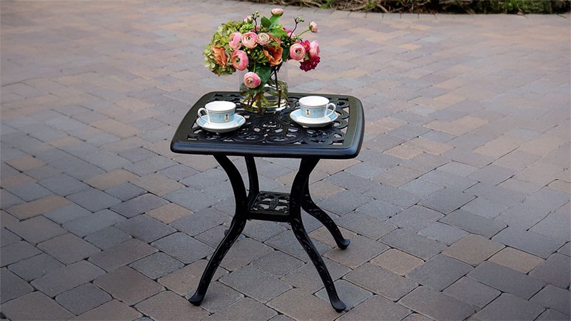 small end table with vase of flowers and 2 place settings for tea