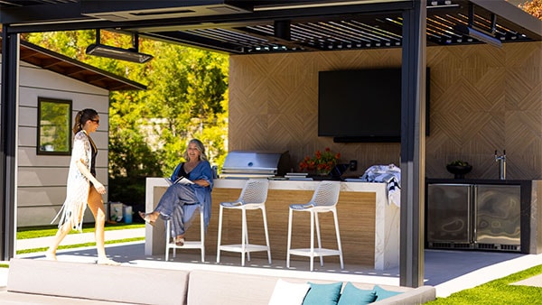 2 women at outdoor kitchen and bar