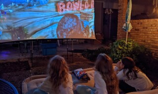 three teens focused on an outdoor movie screen