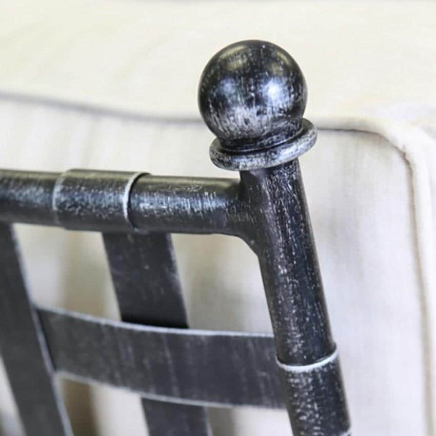 Close-up of a black wrought iron chair ball finial with a cream cushion