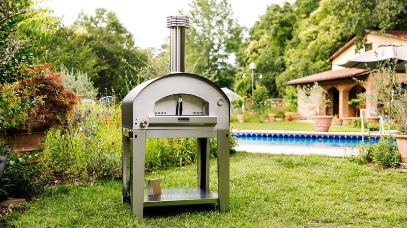 Freestanding Fontana Forni Firenze Pizza Oven in backyard with pool in the background