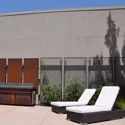 Two modern chaise lounges on the rooftop next to the new outdoor kitchen